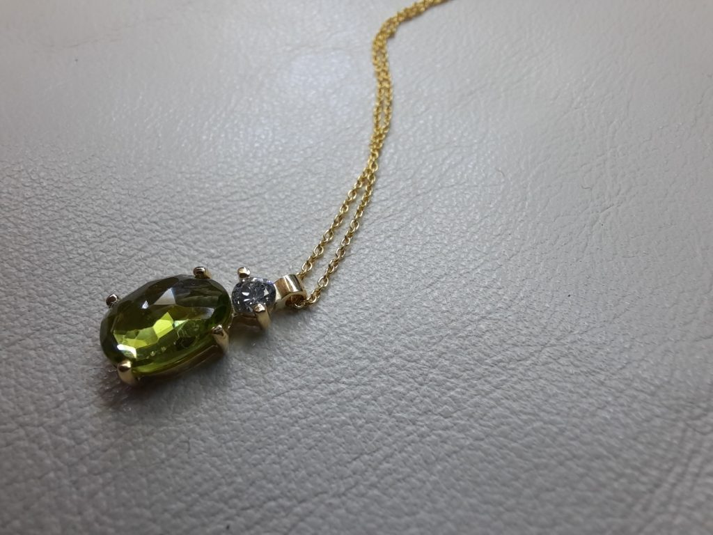 golden necklece with olive colour stone